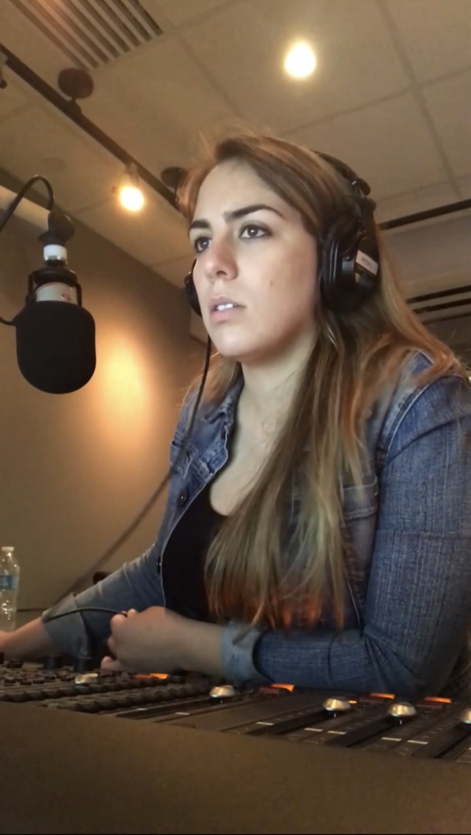 Adrianne anchoring at a radio broadcast board with mic and headphones